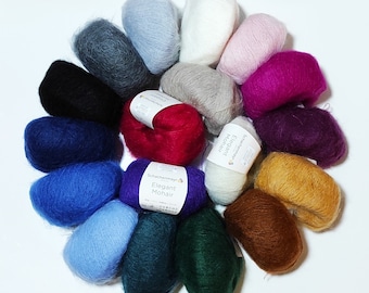 Puede incluir: Una colección de 15 ovillos de lana en varios colores, incluyendo azul, verde, rojo, marrón y morado. La lana está dispuesta en círculo, con las etiquetas hacia afuera. Las etiquetas son blancas con texto negro y muestran las palabras "Schachenmayr" y "Elegant Mohair".