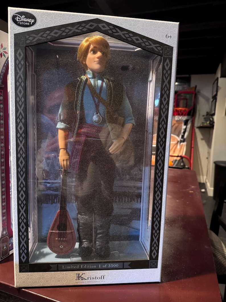 May include: A Kristoff doll from the Disney Store, packaged in a decorative box. The doll wears a blue shirt, dark pants, and a vest, and holds a small stringed instrument. The box is labeled "Limited Edition 1 of 3500."