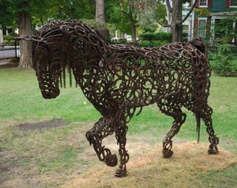 Könnte beinhalten: Eine große Metallskulptur eines Pferdes, die vollständig aus Hufeisen besteht. Die Skulptur ist braun und hat einen rustikalen Look.