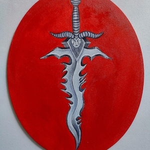May include: An oval painting featuring a silver sword with a jagged, wavy blade and a hilt shaped like a horned face with closed eyes and teardrops. The sword is centered against a solid, vibrant red background, creating a high-contrast visual.