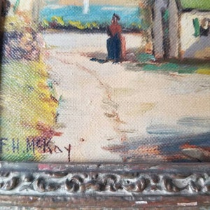 May include: A framed oil painting of a rural scene with a small cottage, a figure in the distance, and a path leading to the cottage. The painting is signed "F.W. McKay" in the lower right corner.