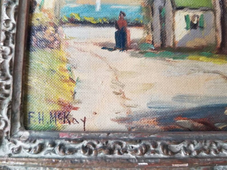 May include: A framed oil painting of a rural scene with a small cottage, a figure in the distance, and a path leading to the cottage. The painting is signed "F.W. McKay" in the lower right corner.