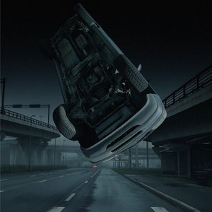 May include: A dark, grainy image of a car flipped upside down on a highway. The car is facing the camera, and the underside of the car is visible. The car is on a highway with a bridge in the background. The image is dark and moody.