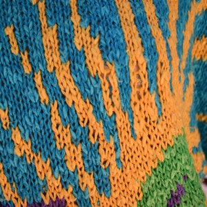 May include: Close-up of a knitted fabric with a striped pattern in shades of blue, yellow, green, and purple.