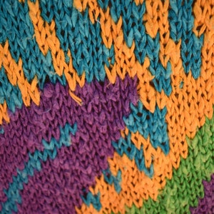 May include: Close-up of a colorful knitted fabric with stripes of blue, orange, purple, green, red, and orange.
