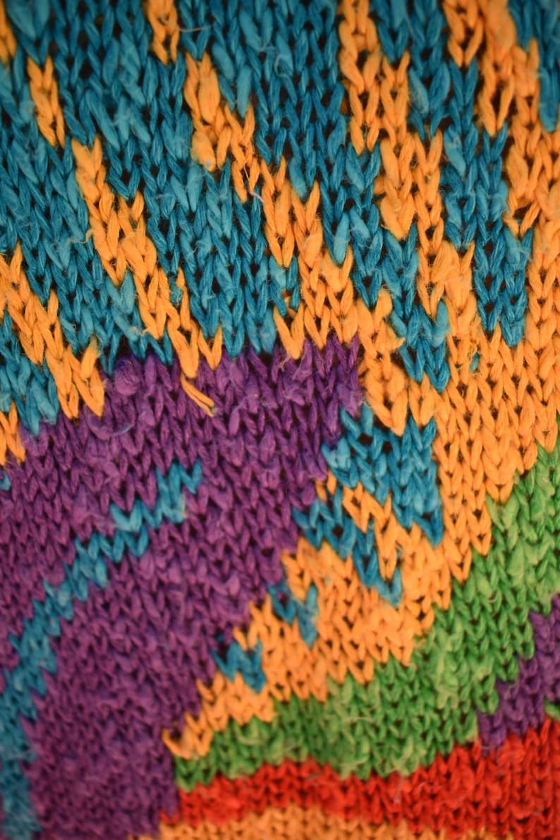 May include: Close-up of a colorful knitted fabric with stripes of blue, orange, purple, green, red, and orange.