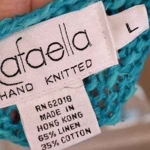 May include: A turquoise blue hand-knitted sweater with a white tag that reads "Rafaella Hand Knitted RN 62018 Made in Hong Kong 65% Linen 35% Cotton" and a size "L" tag.