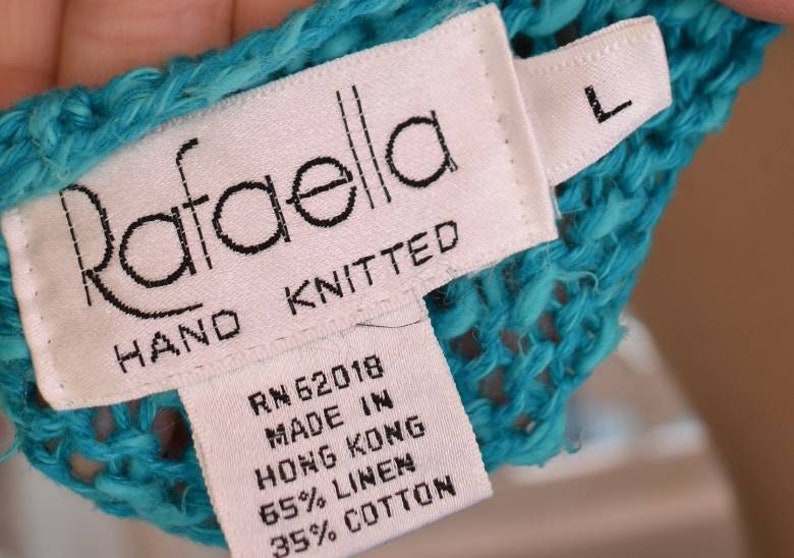 May include: A turquoise blue hand-knitted sweater with a white tag that reads "Rafaella Hand Knitted RN 62018 Made in Hong Kong 65% Linen 35% Cotton" and a size "L" tag.