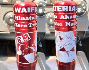 May include: Red metal gear shift knob with a white anime character design. The knob has the text "WAIFU Hinata Zero Two" and "MATERIAL sa Akame Niko Nami" printed on it.