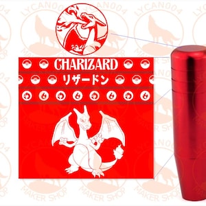 May include: A cylindrical red metal gear shift knob next to a square graphic featuring the character Charizard, the text "CHARIZARD" and "リザードン", and rows of small circular icons including Poké Balls and fire symbols on a bright red background.