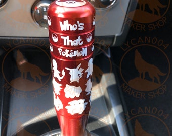 May include: Red gear shift knob with a white design featuring the text "Who's That Pokemon?" and various Pokemon silhouettes.