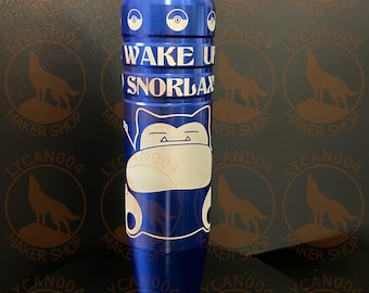 May include: A blue cylindrical object with the text "WAKE UP SNORLAX" in white. The object features a cartoon character design and a circular emblem on top. The background has a repeating pattern of a wolf silhouette and the text "MAKER SHOP LYCAN004".