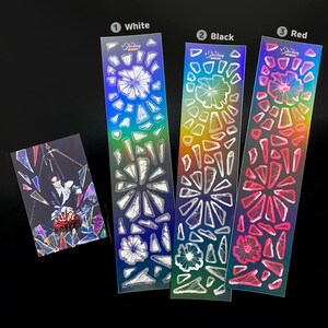 May include: Three sheets of holographic stickers with a rainbow background. Each sheet has a different color: white, black, and red. The stickers are shaped like shards of glass and have a sparkly finish.