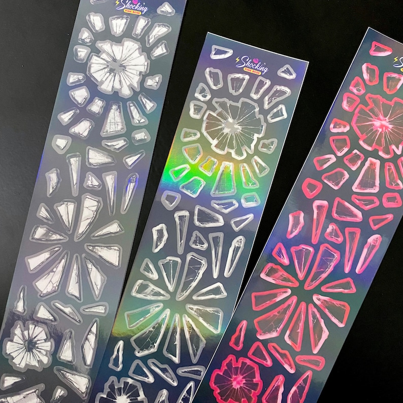 May include: Three sheets of holographic sticker paper with a shattered glass design. The stickers are in white, pink, and black.