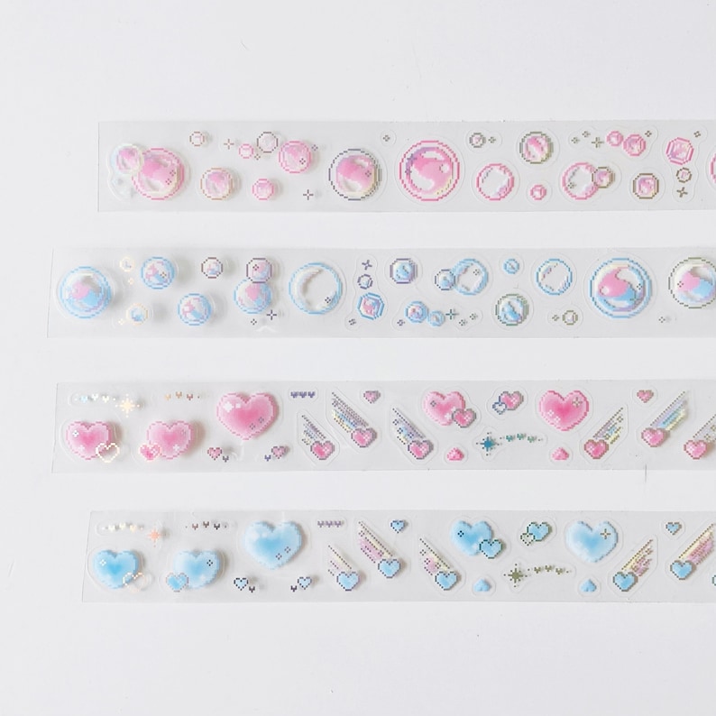 K&ouml;nnte beinhalten: Vier Rollen durchsichtiges Klebeband mit bunten holografischen Designs. Die Designs beinhalten Herzen, Sterne und Blasen.