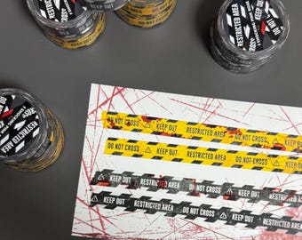 May include: Four clear circular containers with black and yellow lids labeled RESTRICTED AREA and SHOCKING PINK ROSE, alongside a rectangular sheet featuring two yellow and two black adhesive strips printed with DO NOT CROSS and KEEP OUT.