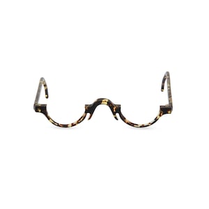 Puede incluir: Un par de gafas de lectura de carey con un diseño de marco curvo único.