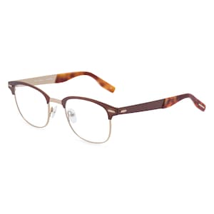 May include: Eyeglasses with a brown and gold frame. The top of the frame and the arms are brown, while the bottom of the frame is gold. The arms have a tortoiseshell pattern at the ends.