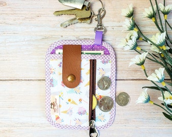 Key ring and card holder made of fabric with 3 pockets. Zipper pocket, slip pocket and clear vinyl pocket with ice-cream print