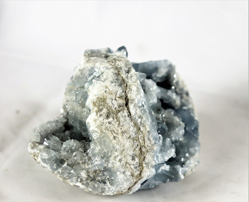 May include: A large, rough, gray and blue celestite crystal cluster with a natural, raw, and unpolished finish.