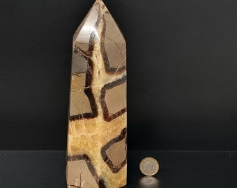Könnte beinhalten: Ein großer, brauner und beiger, natürlicher Stein, spitz, kristallförmig wie eine Pyramide. Der Stein hat ein einzigartiges, gemustertes, geometrisches Design.