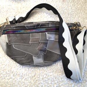 Marsupio in similpelle in stile vintage nei toni del grigio, con effetto rattoppato e rammendato, tracolla regolabile.