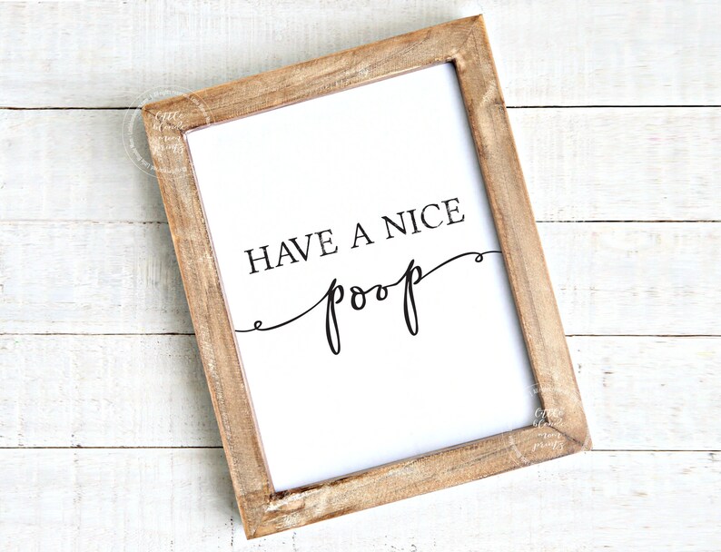 May include: A framed print with the text "Have a nice poop" in a cursive font. The frame is made of wood and has a light brown finish.