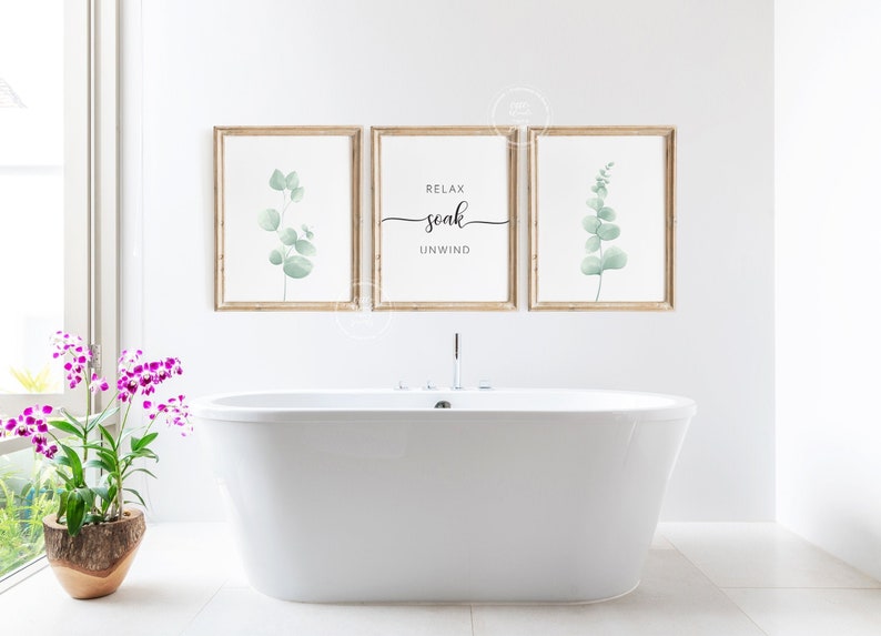 May include: Three framed prints with a white background and a light green eucalyptus leaf design. The center print has the text "Relax soak unwind" in black script font.