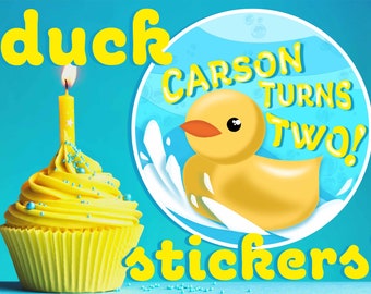 May include: Yellow cupcake with blue sprinkles and a lit candle. A yellow rubber ducky in a blue circle with white waves and the text "CARSON TURNS TWO!"  The text "duck stickers!" is below the circle.