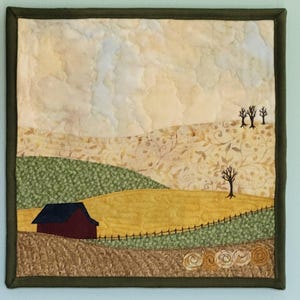 May include: A quilted wall hanging depicting a rural landscape. The scene includes a red barn, rolling hills in shades of green and yellow, and a cloudy sky. The piece is framed with a dark green border.
