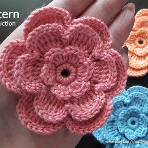 May include: A crochet pattern instruction for making a flower. The image shows three crocheted flowers in pink, blue, and orange.