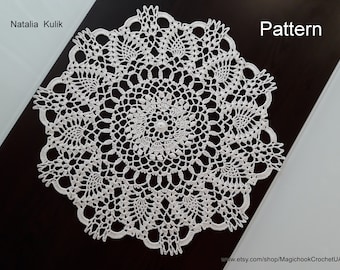 Può includere: Un centrino all'uncinetto bianco con un delicato motivo floreale. Il centrino è circolare e ha un diametro di circa 30 cm. Il motivo è intricato e presenta un motivo centrale circondato da motivi floreali ripetitivi.