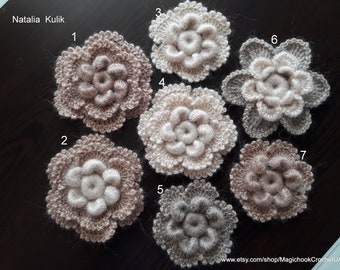 May include: Seven crocheted flowers in various shades of brown, beige, and gray. The flowers are numbered 1 through 7.