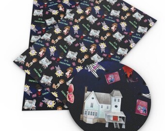 May include: A black and white patterned fabric with a repeating design of a house, a girl, a cat, and the text "It's Showtime". The fabric is shown with a round, black fabric patch with a house and other details from the pattern.