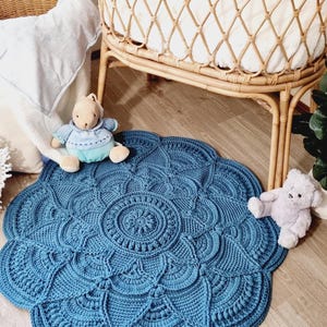 Floral, blue crochet floor rug in front of a baby bassinet.