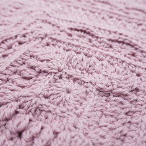 Close up of a pink crochet blanket.