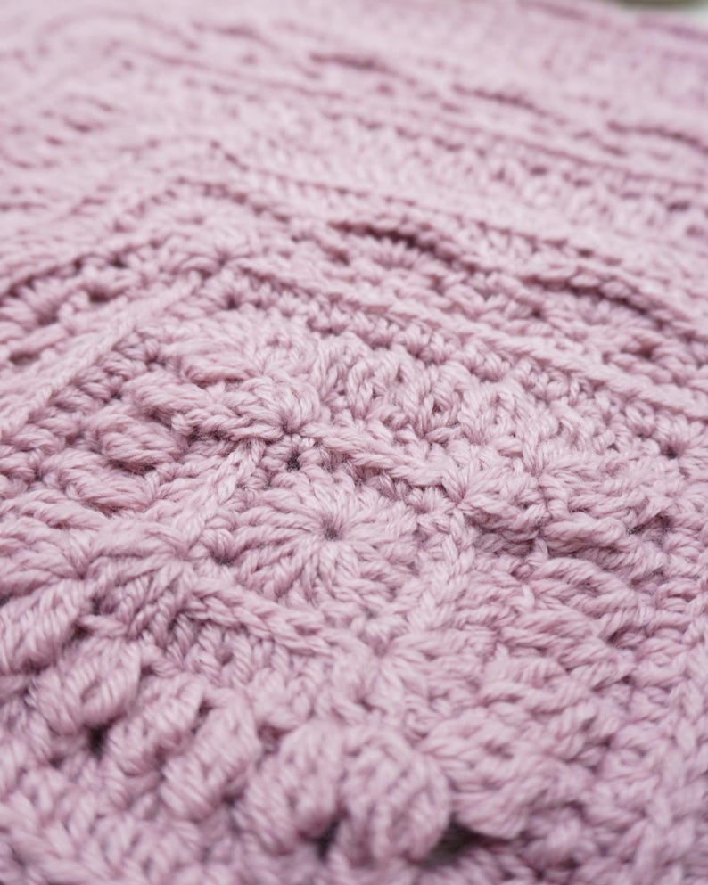 Close up of a pink crochet blanket.