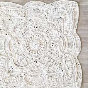 Square, white crochet floor rug.
