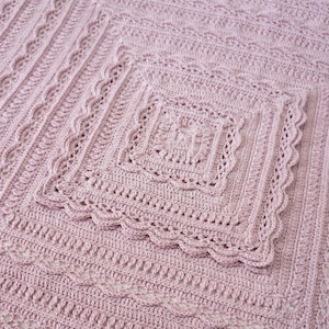 Pink crochet blanket laying flat.