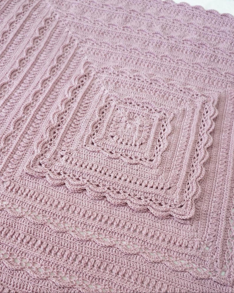 Pink crochet blanket laying flat.