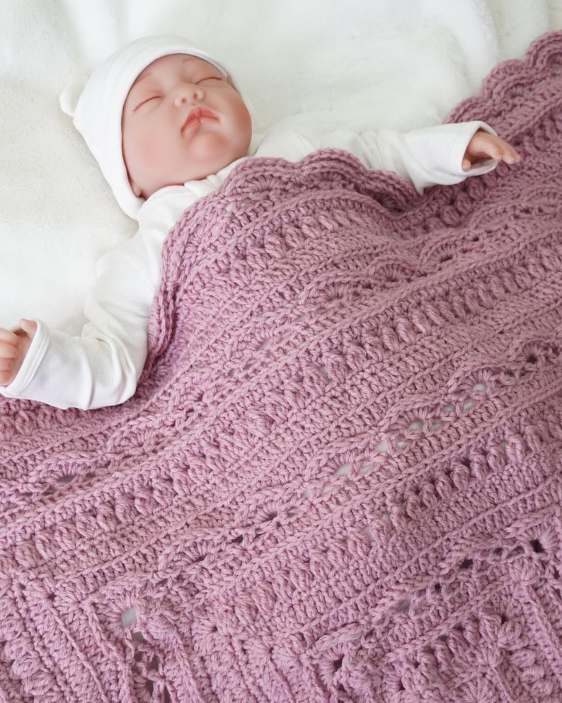Pink crochet blanket with baby.
