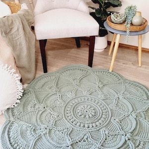 Floral, green crochet floor rug in front of a chair and coffee table.