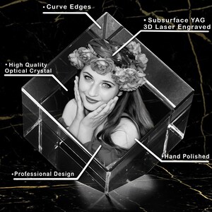 Puede incluir: Un cubo de cristal grabado con l&aacute;ser 3D con una foto en blanco y negro de una mujer con una corona de flores. El cubo tiene bordes curvos y est&aacute; pulido a mano. El texto "Subsurface YAG 3D Laser Engraved" es visible en la imagen.