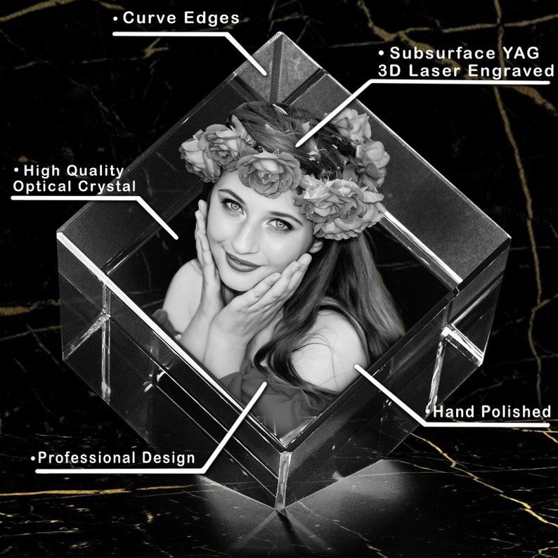 Puede incluir: Un cubo de cristal grabado con l&aacute;ser 3D con una foto en blanco y negro de una mujer con una corona de flores. El cubo tiene bordes curvos y est&aacute; pulido a mano. El texto "Subsurface YAG 3D Laser Engraved" es visible en la imagen.