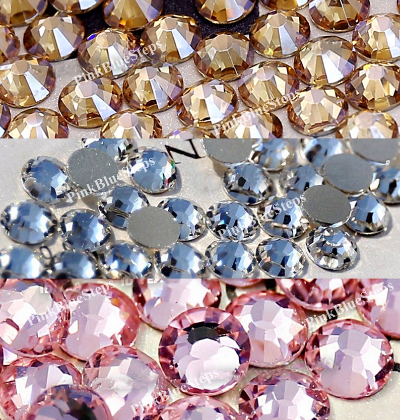 May include: Assortment of rhinestones in three colors: gold, clear, and pink. The rhinestones are small and round, with a faceted surface.