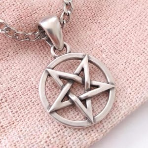 Op de afbeelding: Een zilverkleurige metalen hanger met een vijfpuntige ster in een cirkelvormig frame, hangend aan een bijpassende schakelketting. De hanger heeft een gladde, gepolijste afwerking met subtiel donkere verdiepte delen.