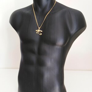 May include: A gold chain necklace with a gold pendant featuring the Eye of Horus symbol.