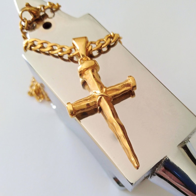 May include: A gold-toned cross pendant necklace with a textured, hammered finish. The cross is on a silver-toned chain.