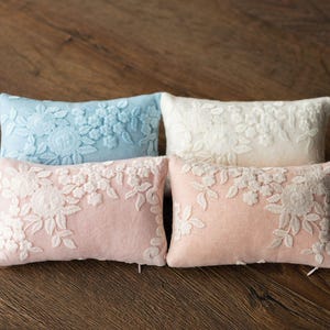 Newborn posing pillow — soft pastel shades, plush support, and essential prop for cozy, timeless baby photography