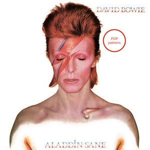May include: A close-up portrait of David Bowie with a red and blue lightning bolt painted on his face. The image is from the Aladdin Sane album cover. The text "PDF pattern" is in a red circle in the upper right corner of the image.